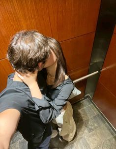 a man and woman kissing in an elevator