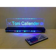 a remote control sitting on top of a table next to a sign that says toni calender