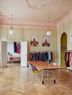 an empty room with clothes hanging on the walls and wooden flooring in front of it