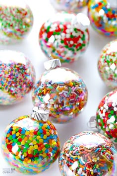 there are many colorful sprinkles on the cake balls that have been decorated with white, red, yellow, and blue