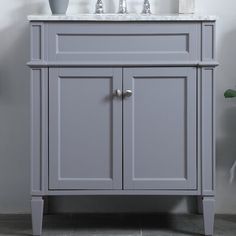 a bathroom vanity with two sinks and a mirror above the sink in front of a white wall