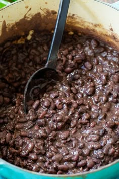 a pot full of beans with a spoon in it