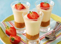 three desserts on a plate with strawberries