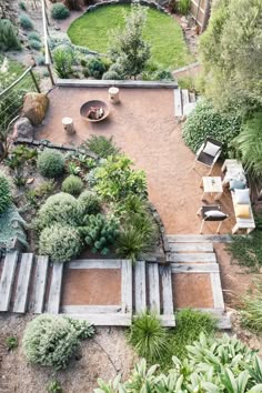 an aerial view of a backyard garden with seating and trees in the backgroud