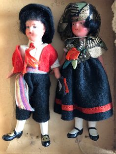 two dolls are standing next to each other