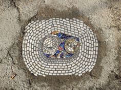 a manhole cover on the ground with mosaic tiles