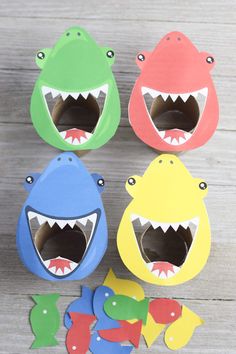 four paper cut outs with shark and fish on the bottom one has its mouth open