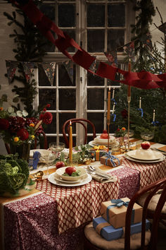 the table is set for christmas dinner by the window