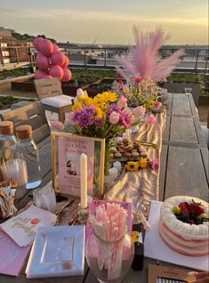 a table topped with cake and flowers on top of a wooden table