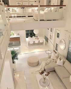 an aerial view of a living room with white furniture and large open floor to ceiling windows