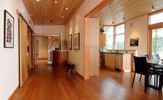 an open living room and dining area with hard wood flooring on both sides of the room