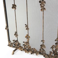 an iron screen with flowers and leaves on the sides, set against a white background