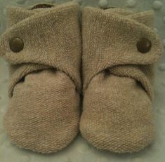 a pair of brown slippers sitting on top of a bed