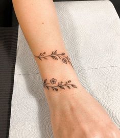 a woman's arm with a flower tattoo on her left wrist and the word love written in it