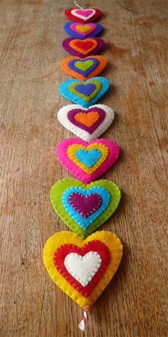 a row of multicolored hearts on a wooden table