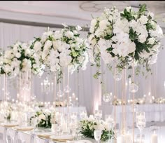 the tables are set with white flowers and candles