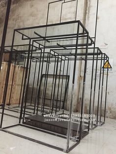 several metal cages sitting on the floor in an empty room with no people around them