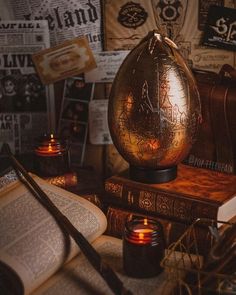 an open book on top of a table next to a candle and some other items