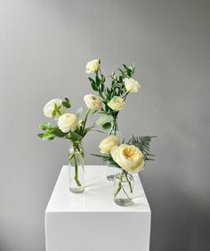 two vases with flowers are sitting on a table