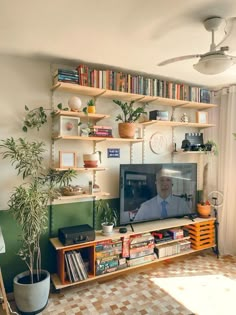 a living room filled with furniture and a flat screen tv sitting on top of a wooden shelf