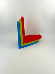 a red and blue chair sitting on top of a white floor next to a wall