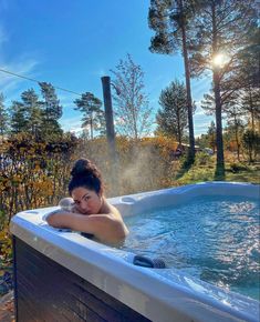 a woman is relaxing in the hot tub on a sunny day with her head resting on her hand