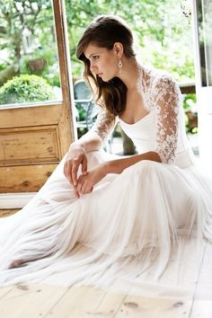 a woman sitting on the floor wearing a white dress