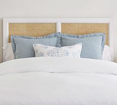 a white bed topped with pillows and blankets