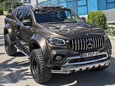 a mercedes benz pickup truck parked in front of a building