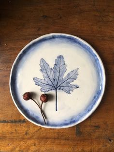 a blue and white plate with a leaf on it