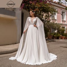 a woman in a white wedding dress standing on the street