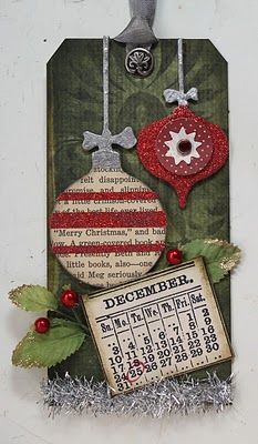 a christmas ornament hanging on a wall next to a calendar and holly leaves