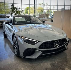 a silver mercedes sports car in a showroom