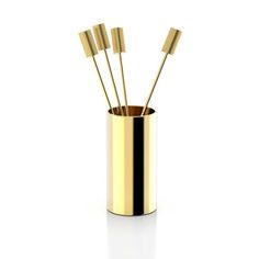 four gold sticks sticking out of a cup