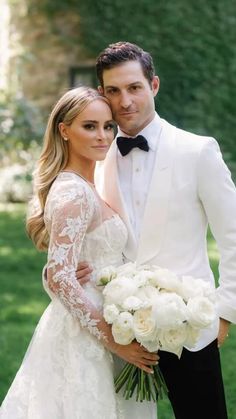 a man in a tuxedo and a woman in a wedding dress pose for a photo