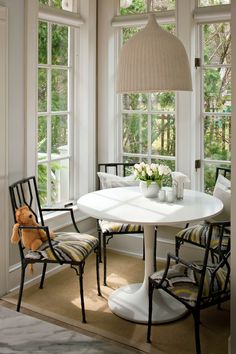 a dining room table with chairs and a teddy bear