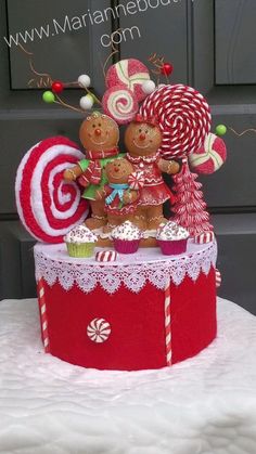 two gingerbread men are standing on top of a red box with candy canes