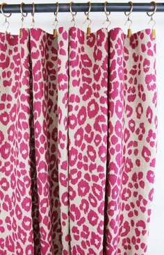 pink and white leopard print curtains hanging from a metal rod