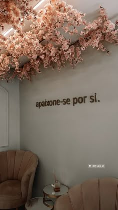 two chairs and a table in front of a wall with writing on the wall behind them