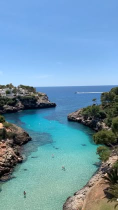 people are swimming in the clear blue water