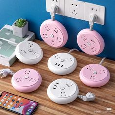 four pink and white electrical outlets on a wooden table