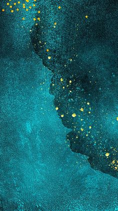 blue and yellow paint splattered on top of a black surface with gold dots