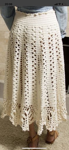 a woman is wearing a white crochet skirt