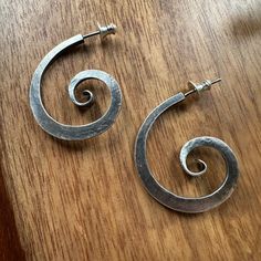 Hand forged sterling silver is antiqued to enhance the medieval, ironwork aesthetic of these spiral earrings. These earrings are 1.25" long and 1" wide. Handmade in Boston, MA. Hand Forged Spiral Metal Earrings, Unique Hand Forged Spiral Earrings, Iron Jewelry, Spiral Earrings, Iron Age, Boston Ma, Caicos Islands, Pitcairn Islands, In Boston