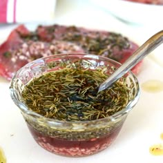 a spoon in a jar filled with herbs