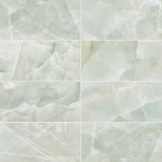 four squares of white marble with green veining on the edges and bottom, all in different shades