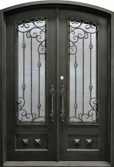 an ornate iron door with glass panels and wrought bars on the top, in black