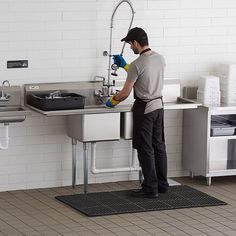 a man is washing his hands in the kitchen sink with a sprayer on it