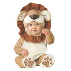 a baby in a lion costume sitting on the floor with his paws up to his face