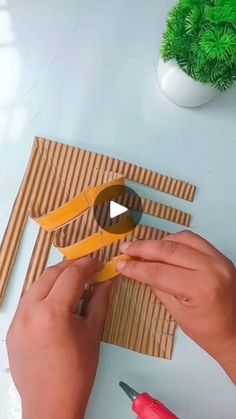 someone using scissors to cut paper on a piece of cardboard